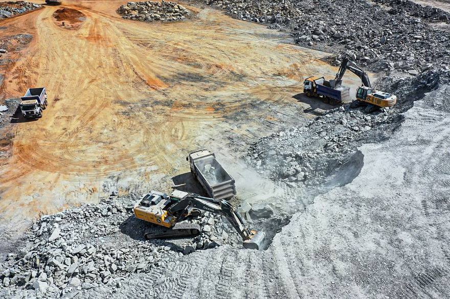 Escavadeiras e caminhões em operação de mineração